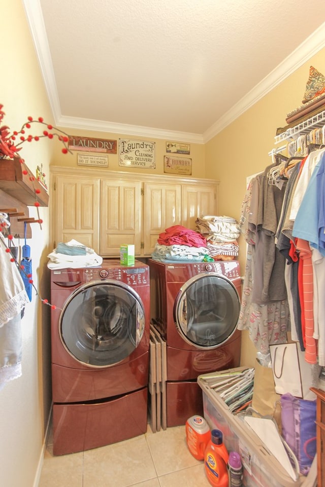 washroom with washer and clothes dryer, cabinets, light tile patterned floors, and crown molding