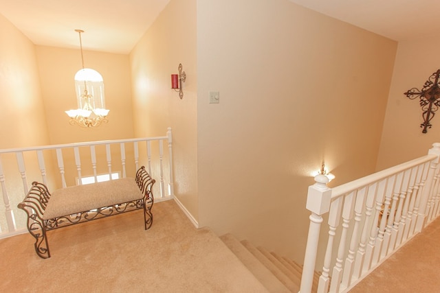 corridor with carpet flooring and a notable chandelier