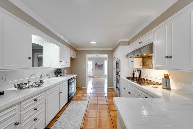 kitchen featuring tasteful backsplash, tile counters, and white cabinets