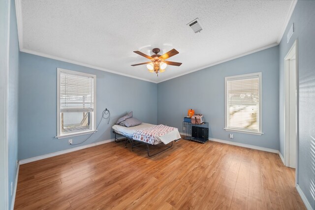 unfurnished bedroom with a textured ceiling, light hardwood / wood-style flooring, ceiling fan, and crown molding