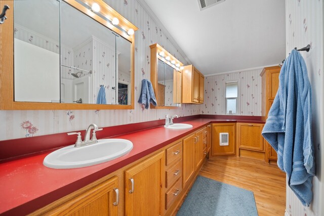 bathroom with wood-type flooring, vanity, and ornamental molding