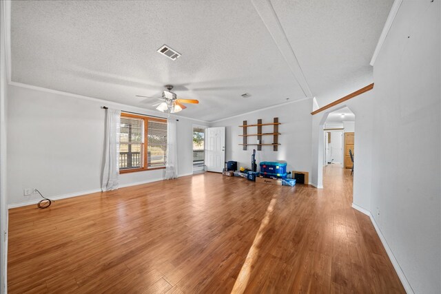 unfurnished living room featuring hardwood / wood-style flooring, crown molding, and a textured ceiling