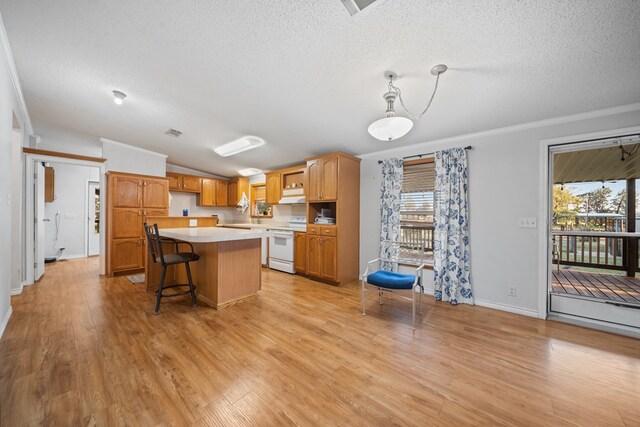 kitchen featuring a kitchen bar, a kitchen island, crown molding, light hardwood / wood-style floors, and white range with electric cooktop