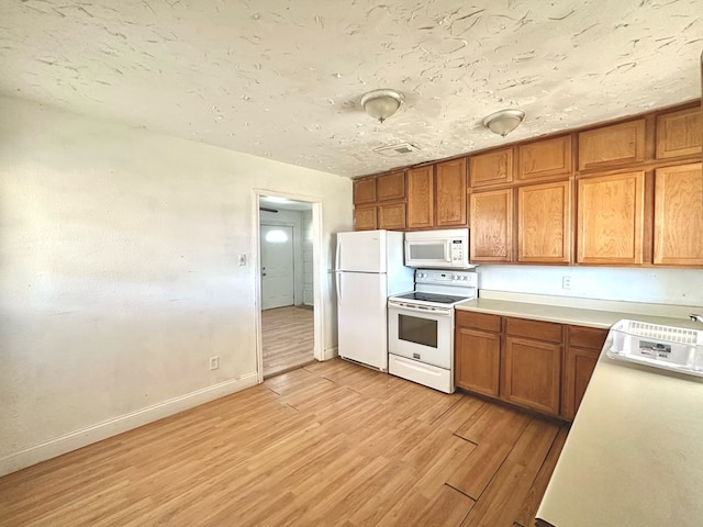 kitchen with white appliances and light wood-type flooring