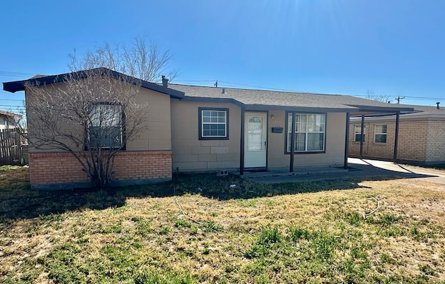 single story home with a front yard and a carport