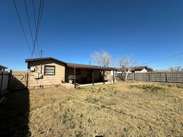 rear view of property featuring a patio and a lawn