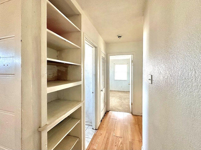 corridor with light hardwood / wood-style flooring