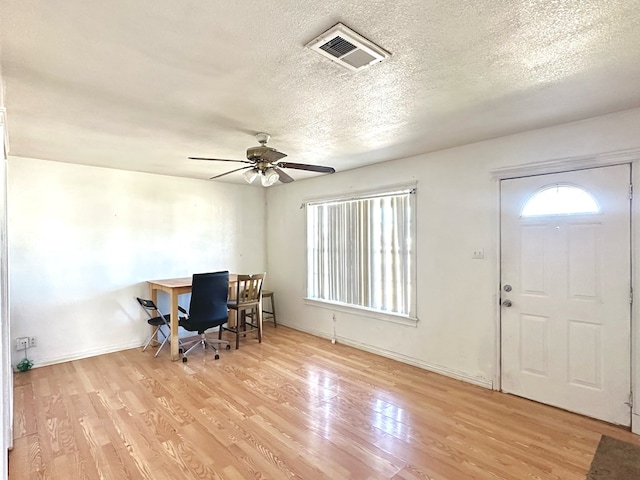 entrance foyer with ceiling fan, light hardwood / wood-style flooring, and a textured ceiling