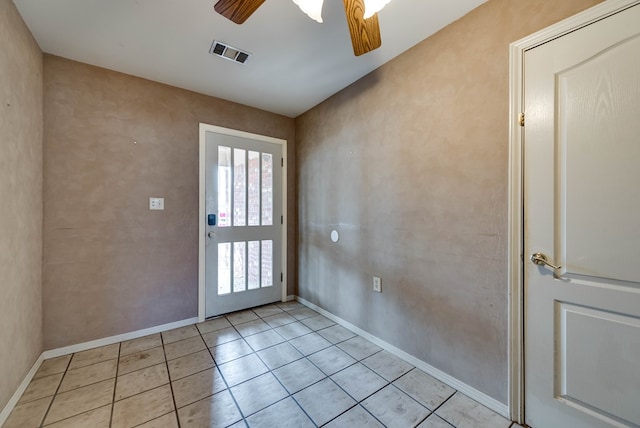 doorway with visible vents, baseboards, ceiling fan, and light tile patterned floors