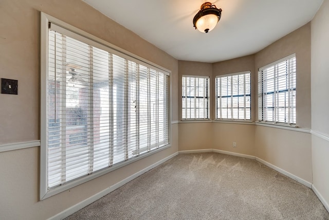 carpeted spare room featuring baseboards