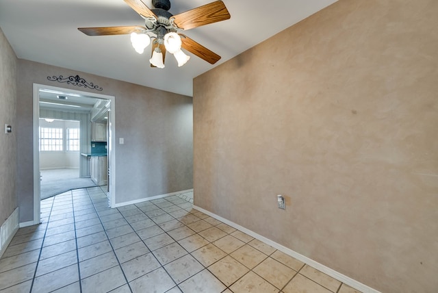 unfurnished room featuring baseboards, ceiling fan, and light tile patterned flooring