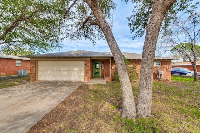 ranch-style house with an attached garage, central air condition unit, driveway, and brick siding