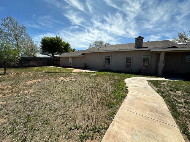 rear view of property featuring a lawn