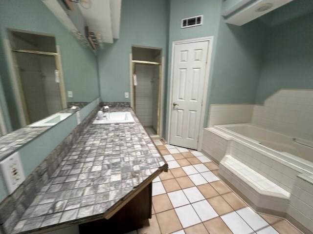 bathroom featuring vanity, tile patterned flooring, and plus walk in shower