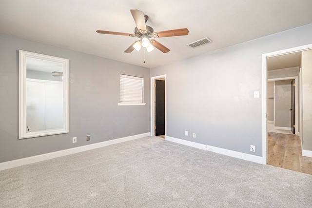 unfurnished bedroom featuring ceiling fan and light carpet