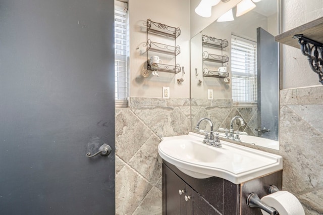 bathroom featuring vanity and tile walls