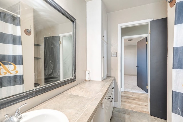 bathroom with curtained shower, vanity, and wood-type flooring