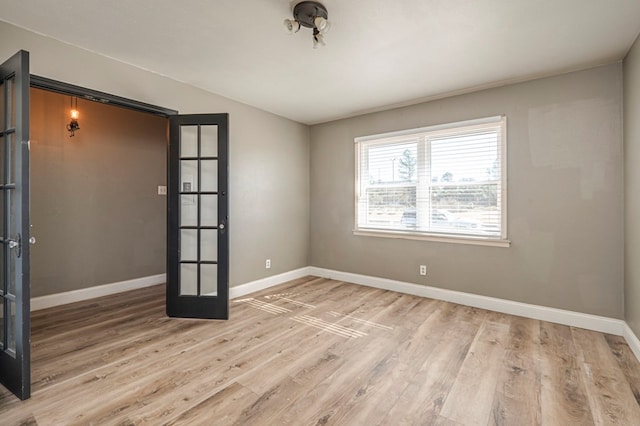 empty room featuring light hardwood / wood-style flooring and french doors