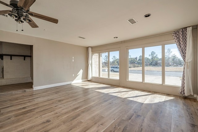 empty room with ceiling fan and light hardwood / wood-style flooring