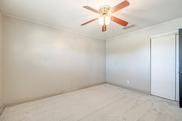 carpeted spare room featuring ceiling fan