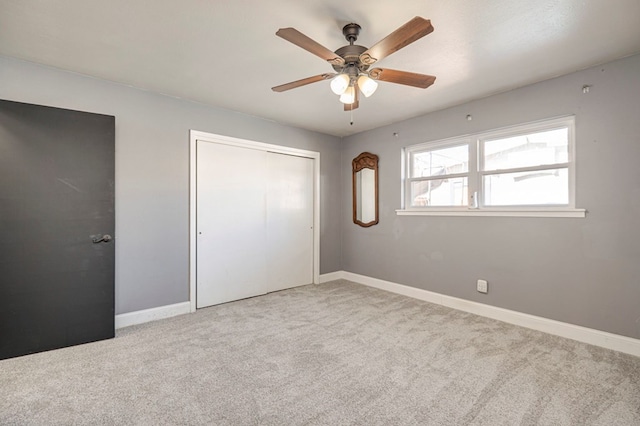 unfurnished bedroom featuring ceiling fan, light carpet, and a closet