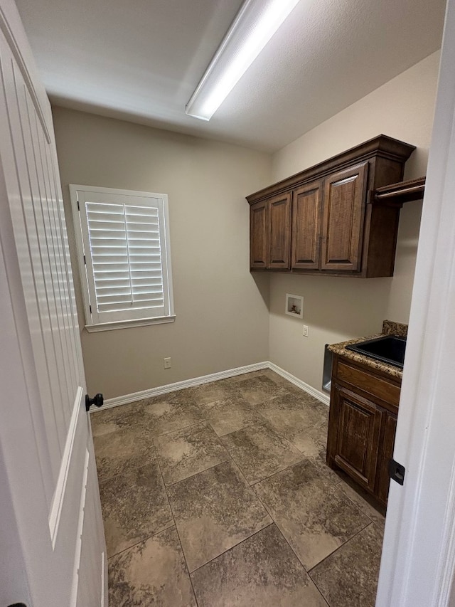 washroom with cabinets, washer hookup, and sink