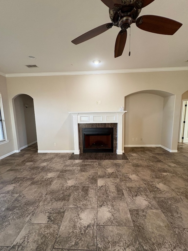 unfurnished living room with ceiling fan, crown molding, and a tiled fireplace