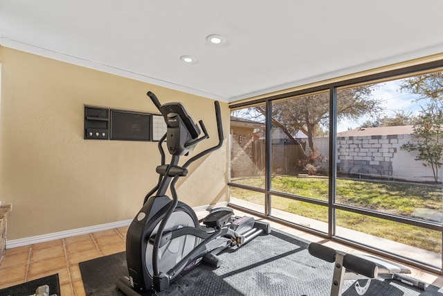 exercise area with ornamental molding and tile patterned floors