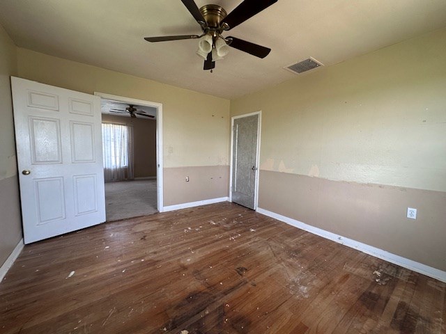 999 S County Rd 183, Snyder, TX 79549 - unfurnished bedroom featuring hardwood / wood-style flooring, baseboards, and ceiling fan