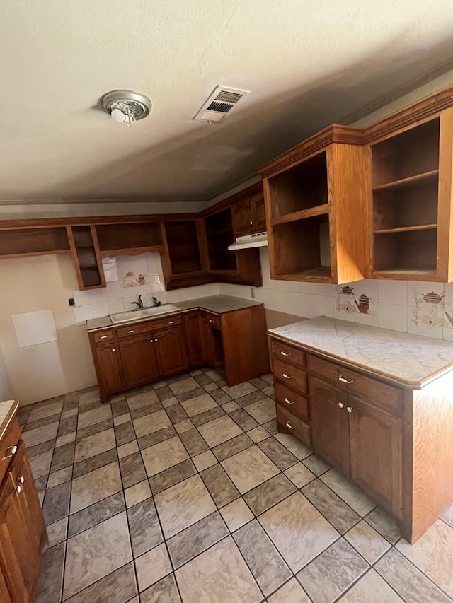 kitchen featuring visible vents, a sink, decorative backsplash, and open shelves