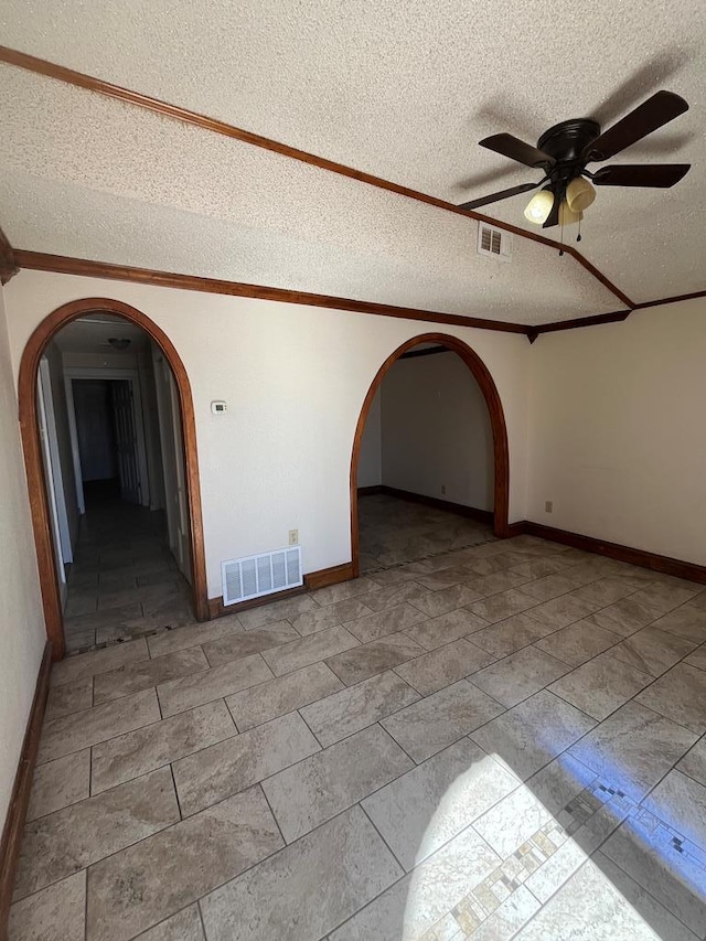 unfurnished room featuring visible vents, arched walkways, and crown molding