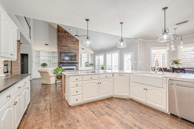 kitchen featuring stainless steel dishwasher, white cabinets, hanging light fixtures, and vaulted ceiling