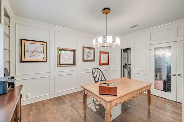 dining space featuring built in shelves, dark hardwood / wood-style flooring, and an inviting chandelier