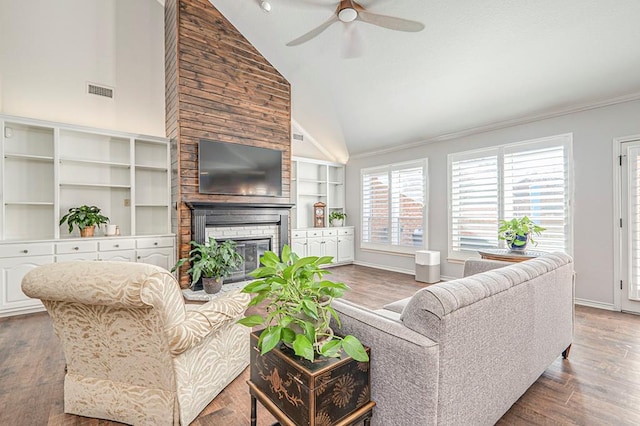 living room featuring hardwood / wood-style flooring, ceiling fan, a fireplace, and high vaulted ceiling