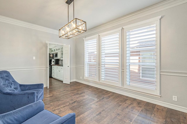 living area featuring ornamental molding, dark wood-type flooring, and a notable chandelier