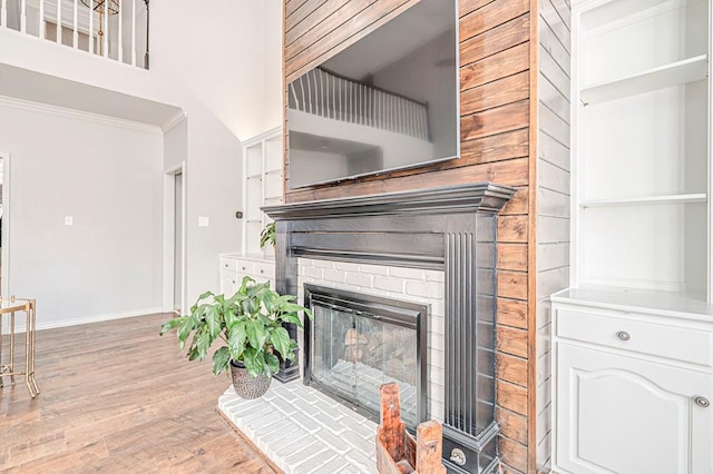 details featuring hardwood / wood-style floors, ornamental molding, and a brick fireplace