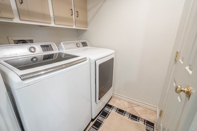 1115 Gulf Ave, Midland, TX 79705 - clothes washing area featuring washing machine and dryer, baseboards, and cabinet space