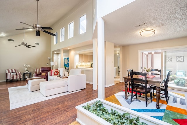 1115 Gulf Ave, Midland, TX 79705 - living room featuring a textured ceiling, wood finished floors, ceiling fan, and a towering ceiling
