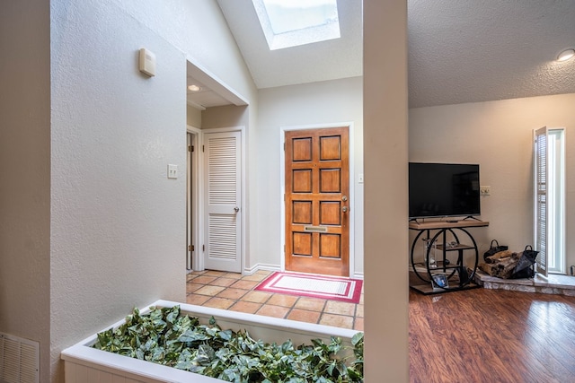1115 Gulf Ave, Midland, TX 79705 - entryway with a skylight, lofted ceiling, a textured wall, and wood finished floors