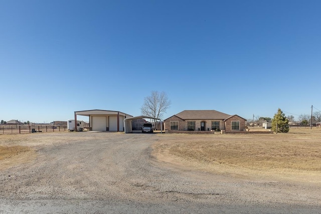 single story home featuring a rural view, a garage, and a carport