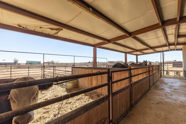 view of horse barn with a rural view