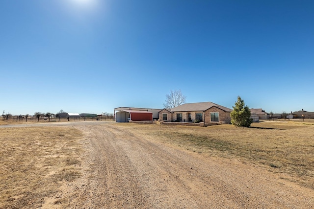 ranch-style home with a front lawn and a rural view