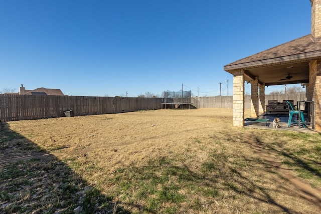 view of yard with ceiling fan, a patio area, and a trampoline