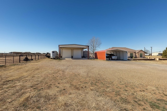 view of yard with a carport, a garage, and an outdoor structure