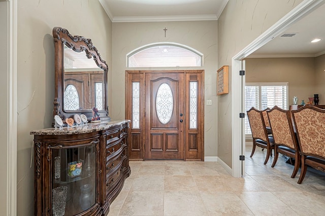 entryway with ornamental molding, visible vents, and baseboards