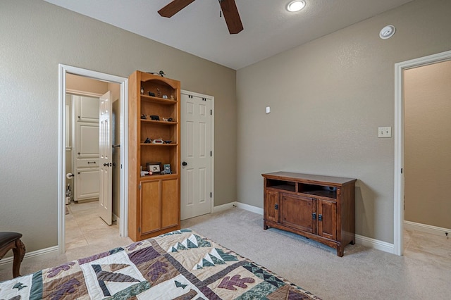 bedroom featuring light colored carpet, ceiling fan, and baseboards