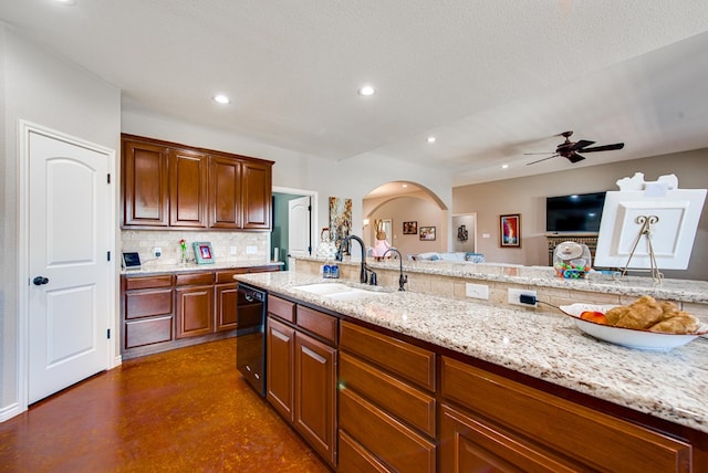 kitchen with dishwasher, a sink, arched walkways, decorative backsplash, and concrete floors