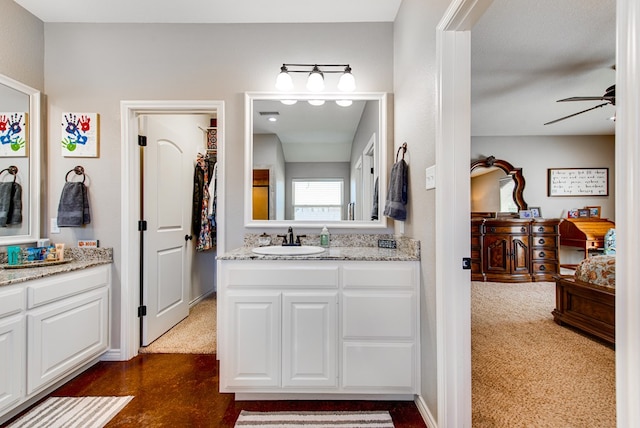 bathroom featuring two vanities, a ceiling fan, and a sink