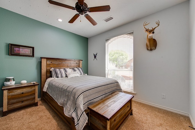 bedroom with visible vents, a ceiling fan, baseboards, and light carpet