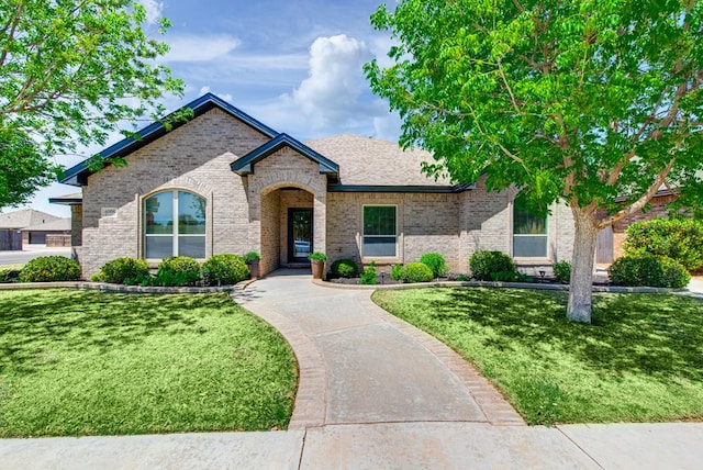 view of front facade with a front lawn and brick siding